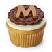 A cupcake with a letter m on top.