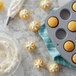 A Wilton non-stick mini muffin pan filled with cupcakes next to a pastry bag.