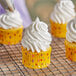 A yellow cupcake with Rich's Bettercreme vanilla whipped icing and white polka dots.