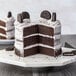A slice of cake with Rich's Bettercreme Oreo Whipped Icing and Oreo cookie crumbles on top.