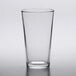 An Arcoroc mixing glass with a black rim on a white surface.