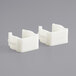 Two white plastic Lancaster Table & Seating replacement clamps.