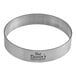 A circular stainless steel tart ring with a logo on it.