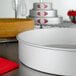 A Fat Daddio's round anodized aluminum cake pan on a metal surface.