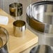 A stack of Fat Daddio's stainless steel round cake rings on a cutting board.