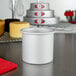 A close up of a Fat Daddio's round anodized aluminum cake pan on a white counter.