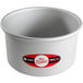 A round anodized aluminum cake pan with a red and white label on it.