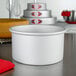 A Fat Daddio's round anodized aluminum cake pan on a white counter.