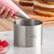 A stainless steel round cake and food ring mold measuring 4 inches by 3 inches.