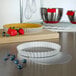 A white Fat Daddio's round fluted tart pan with a removable bottom on a counter.