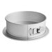 A round white cake pan with a silver handle.