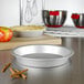 A Fat Daddio's anodized aluminum pie pan on a counter with cinnamon sticks and apples.