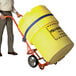 A man pushing a yellow barrel using a yellow and red Wesco Industrial Products drum truck.