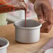 A round anodized aluminum cheesecake pan with straight sides and a removable bottom.