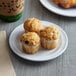 A white Acopa Foundations melamine plate with muffins on it on a table.