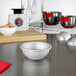 A white bowl on a stainless steel kitchen counter.