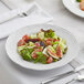 A Tuxton Chicago bright white china plate with salad, figs, and grapes on it.