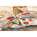 A table set with bright white porcelain teardrop plates and food.
