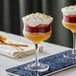Two Acopa Deco rose / cocktail glasses filled with desserts on a tray.