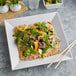 A white square melamine plate with rice, broccoli, and carrots.