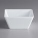 A white square bowl on a gray surface.