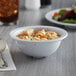 A bowl of noodle soup in a white Acopa Foundations melamine bowl.