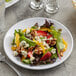 An Acopa Lunar melamine plate with a salad of strawberries, oranges, and nuts.