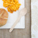 A wooden spoon on a plate of food.