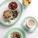 A Corona porcelain plate with a bowl of cereal, nuts, and fruit.