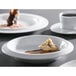 A bright white porcelain bowl filled with food on a table.