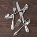 A Fortessa extra heavy weight stainless steel dessert spoon on a table with silverware.