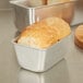 A loaf of bread in a Vollrath aluminum bread loaf pan.