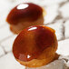 Two red and brown choux pastries in a Sasa Demarle Mini Choux Mold.