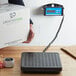 A person using an Avaweigh digital receiving scale to weigh a box.