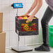 A digital receiving scale with a remote display being used to weigh a crate of assorted produce.