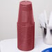 A stack of burgundy plastic cups.