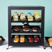 A black Cal-Mil Soho display case with cupcakes and cookies inside.