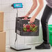 A woman using an Avaweigh low-profile digital receiving scale to weigh a basket of apples.