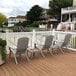 A Grosfillex Westport Barn Gray resin Adirondack chair on a deck.