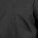 A close-up of the pocket on a black Uncommon Chef cook shirt.