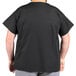 A person wearing a black Uncommon Chef cook shirt.