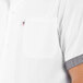 A man wearing a white Uncommon Chef cook shirt with black and white checkered trims and a pocket.