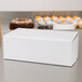 A close up of a white bakery box on a table.