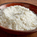 A bowl of Instant Potato Flakes on a table.