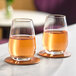 Two Schott Zwiesel Forte stemless wine glasses filled with wine on a table