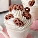 a cup of ice cream with pretzels on top