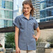 A woman in a steel gray short sleeve Uncommon Chef cook shirt with her hands on her hips.