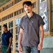 A man wearing a slate grey Uncommon Chef cook shirt.