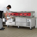 A man opening a drawer in a Beverage-Air commercial chef base in a kitchen.