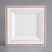 A white square plate with rose gold trim.